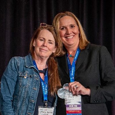 Winner of the Crystal Bell Advocacy Award stands with LifeCourse Nexus Director Michelle Reynolds